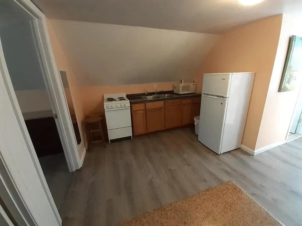 A kitchen with a refrigerator , stove , sink and microwave.