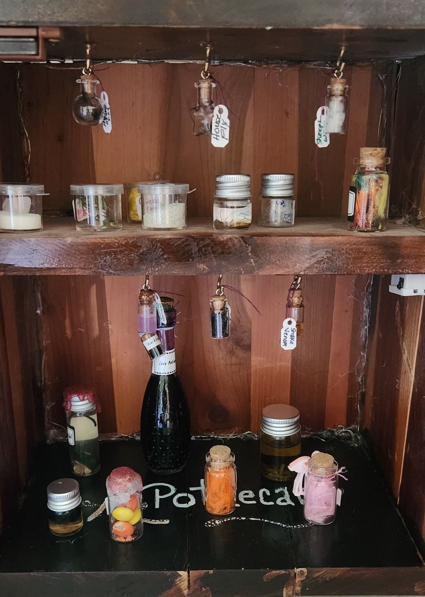 A wooden shelf with bottles of potions on it