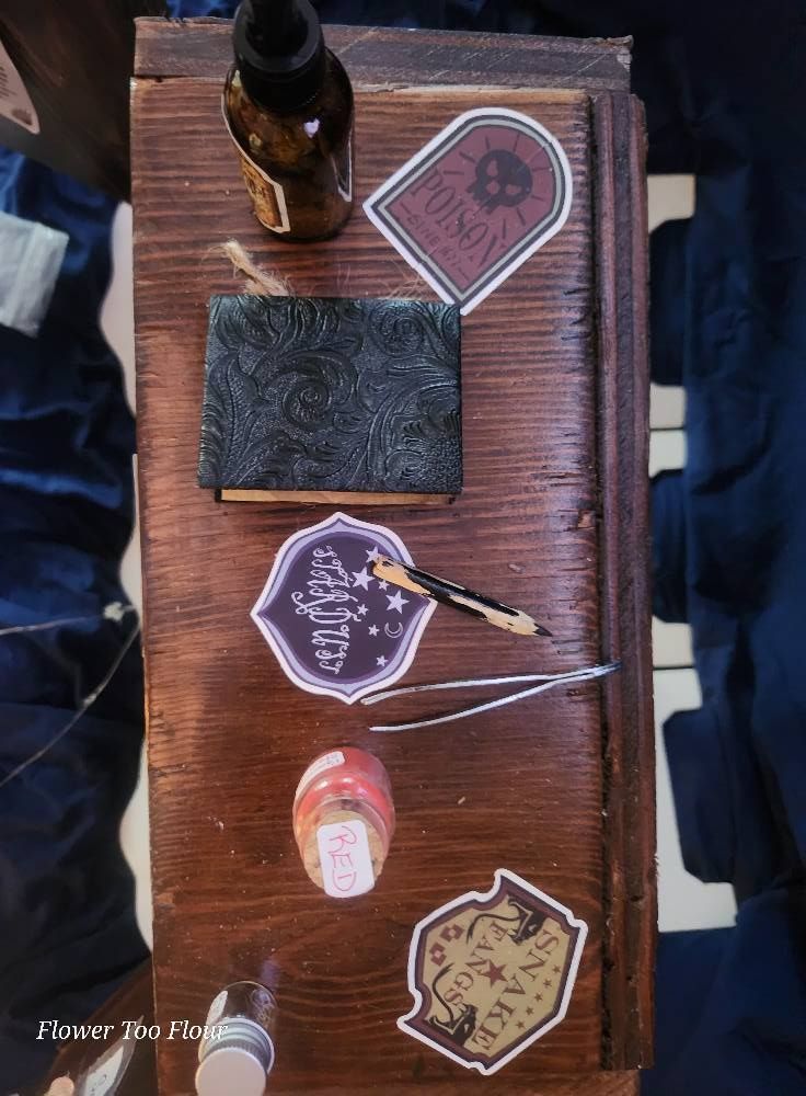 A wooden table with stickers on it and a bottle of alcohol.