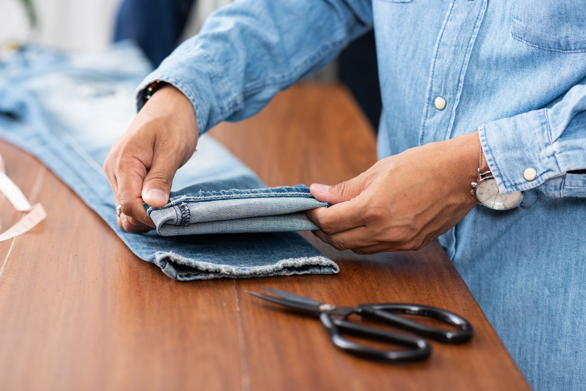 Tailor working with blue denim jeans