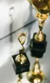 Gold trophies on reflective surface, one small award in front of a larger trophy.