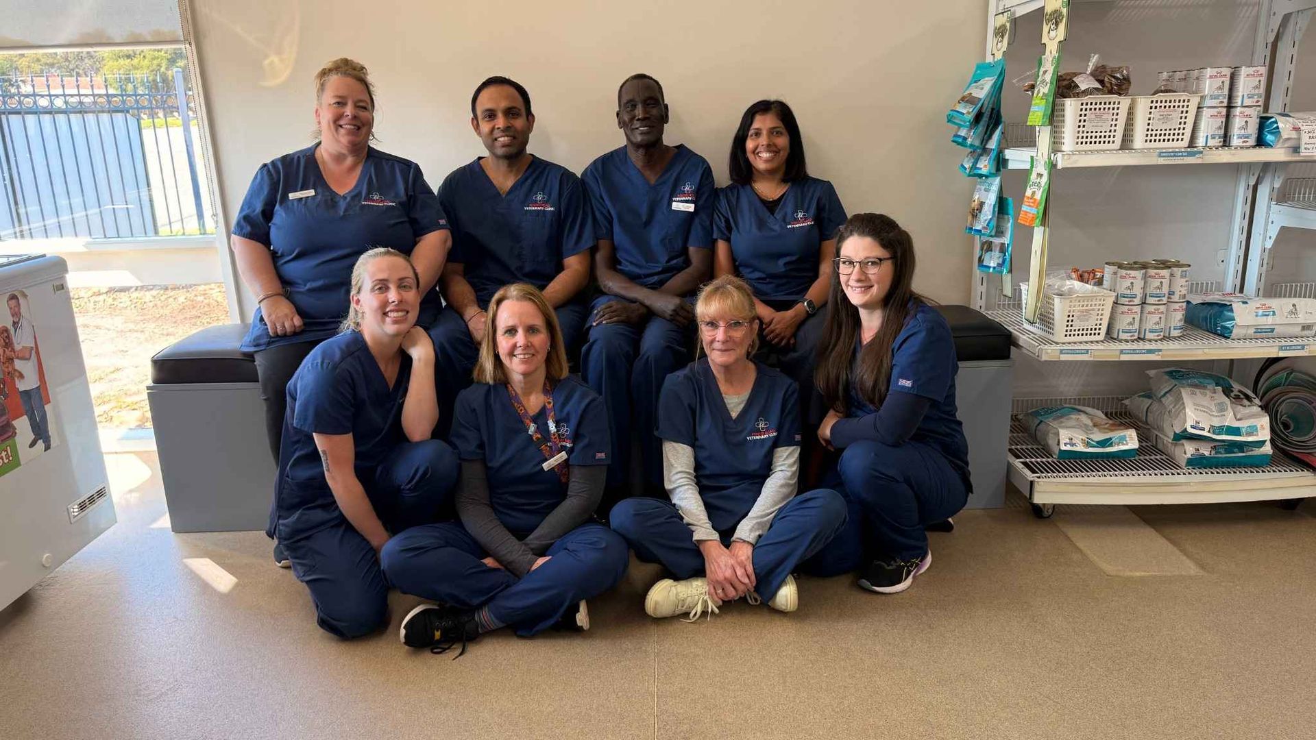 A group of nurses are posing for a picture while sitting on the floor.