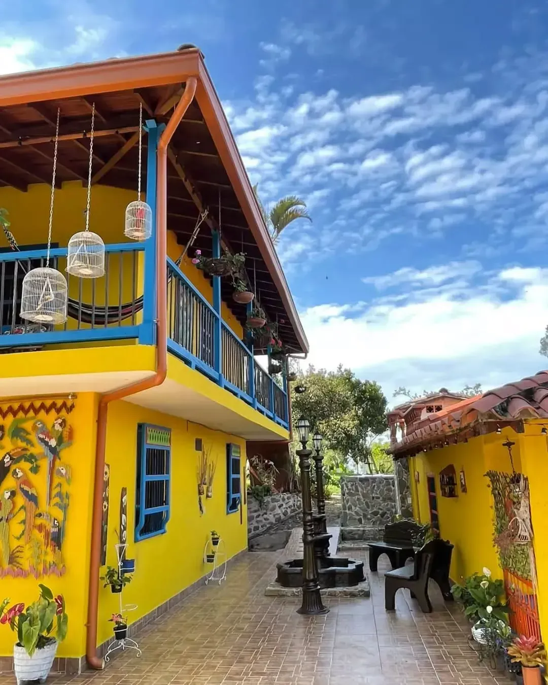 A yellow building with blue windows and a balcony
