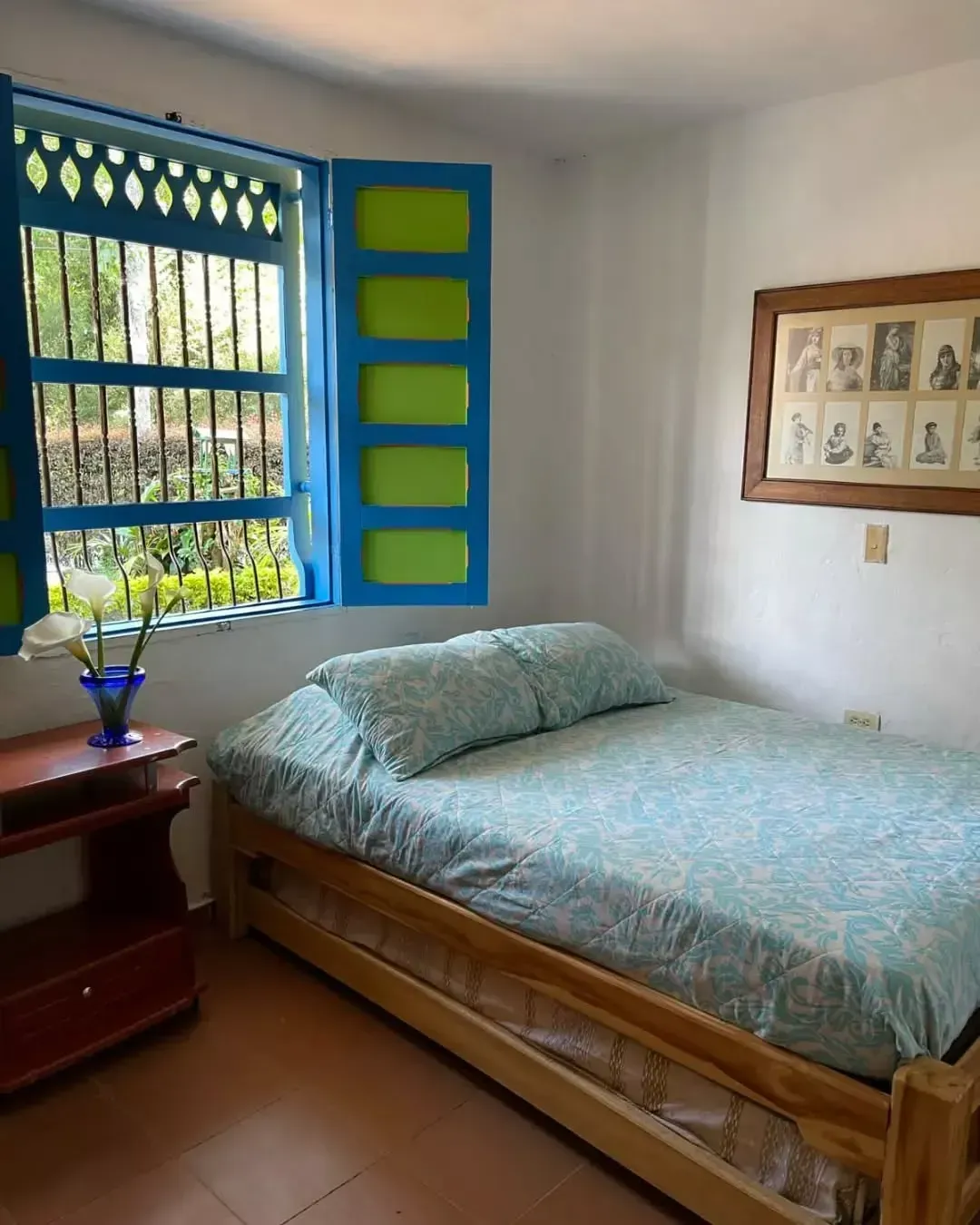 A bedroom with a bed and a blue window