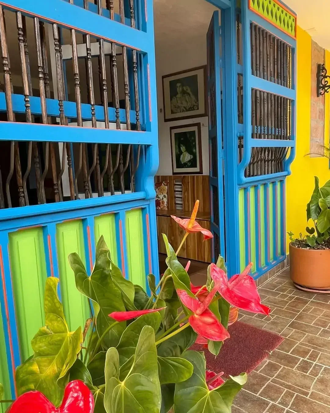 A blue and yellow building with flowers in front of it