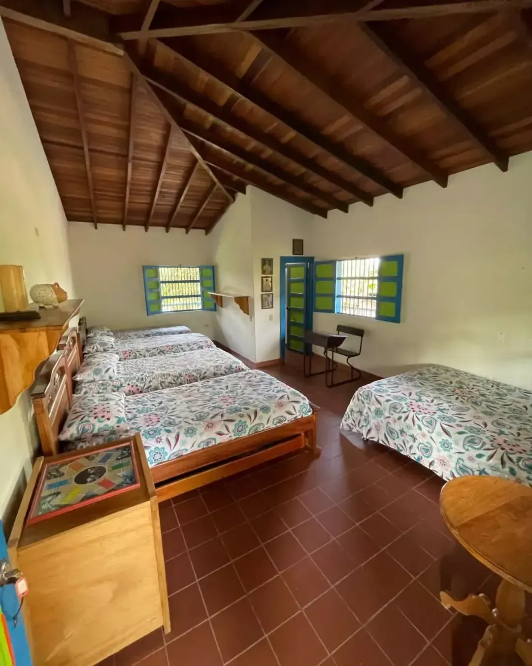 A bedroom with three beds and a wooden ceiling