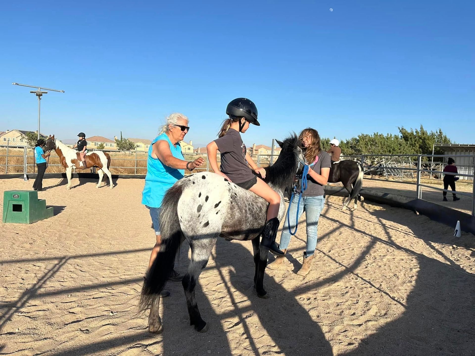 A girl is riding a horse in a fenced in area.