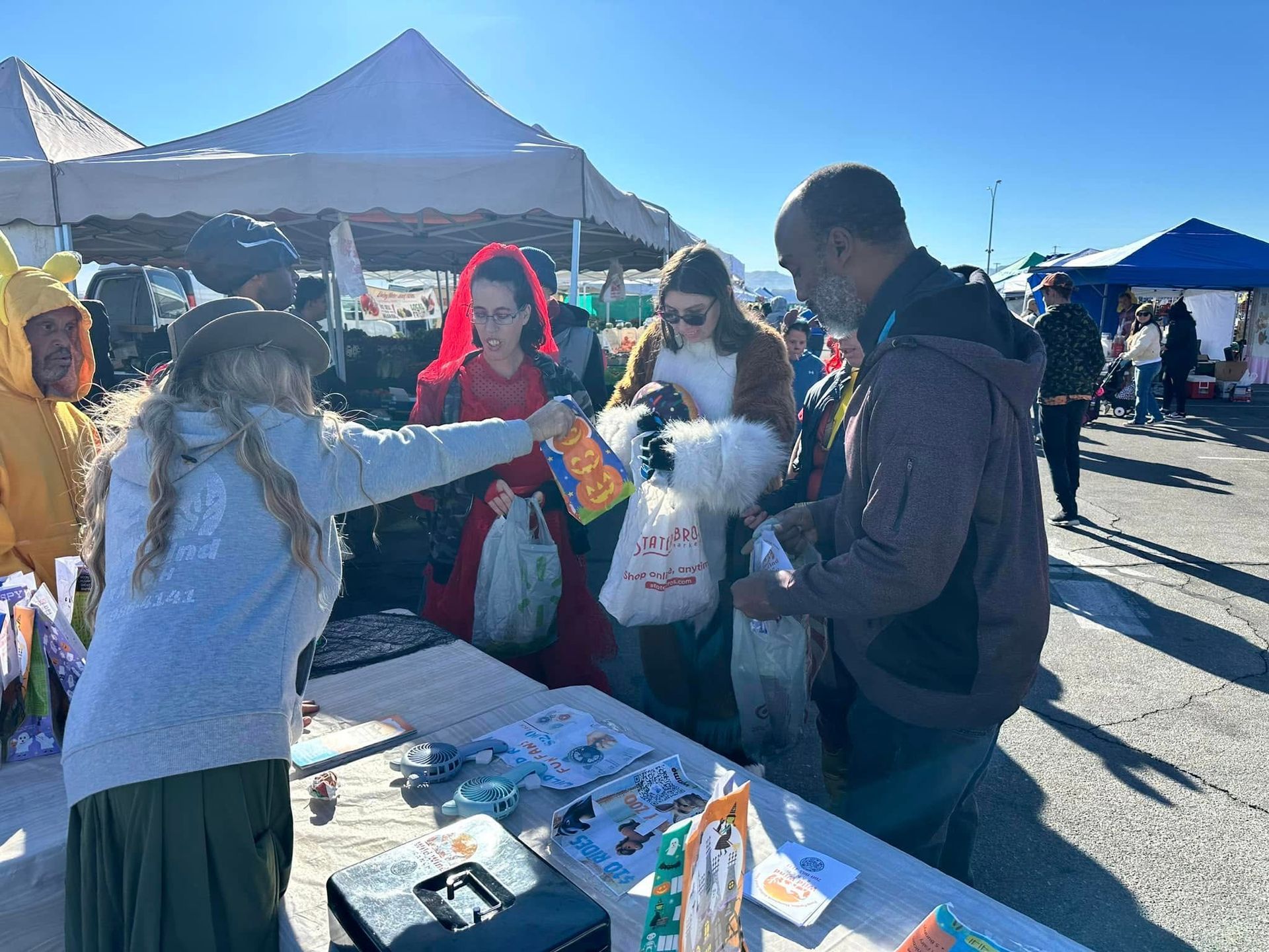 A group of people are standing around a table at a festival.