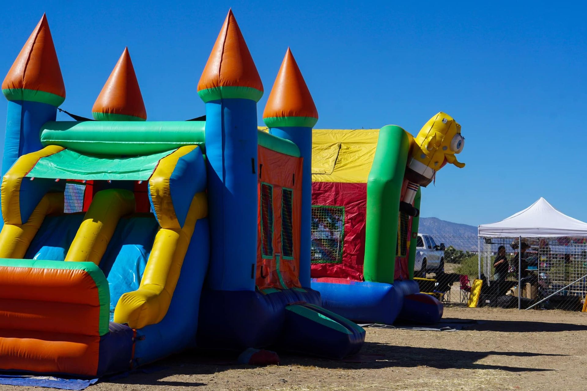 A bunch of bouncy houses are lined up in a field