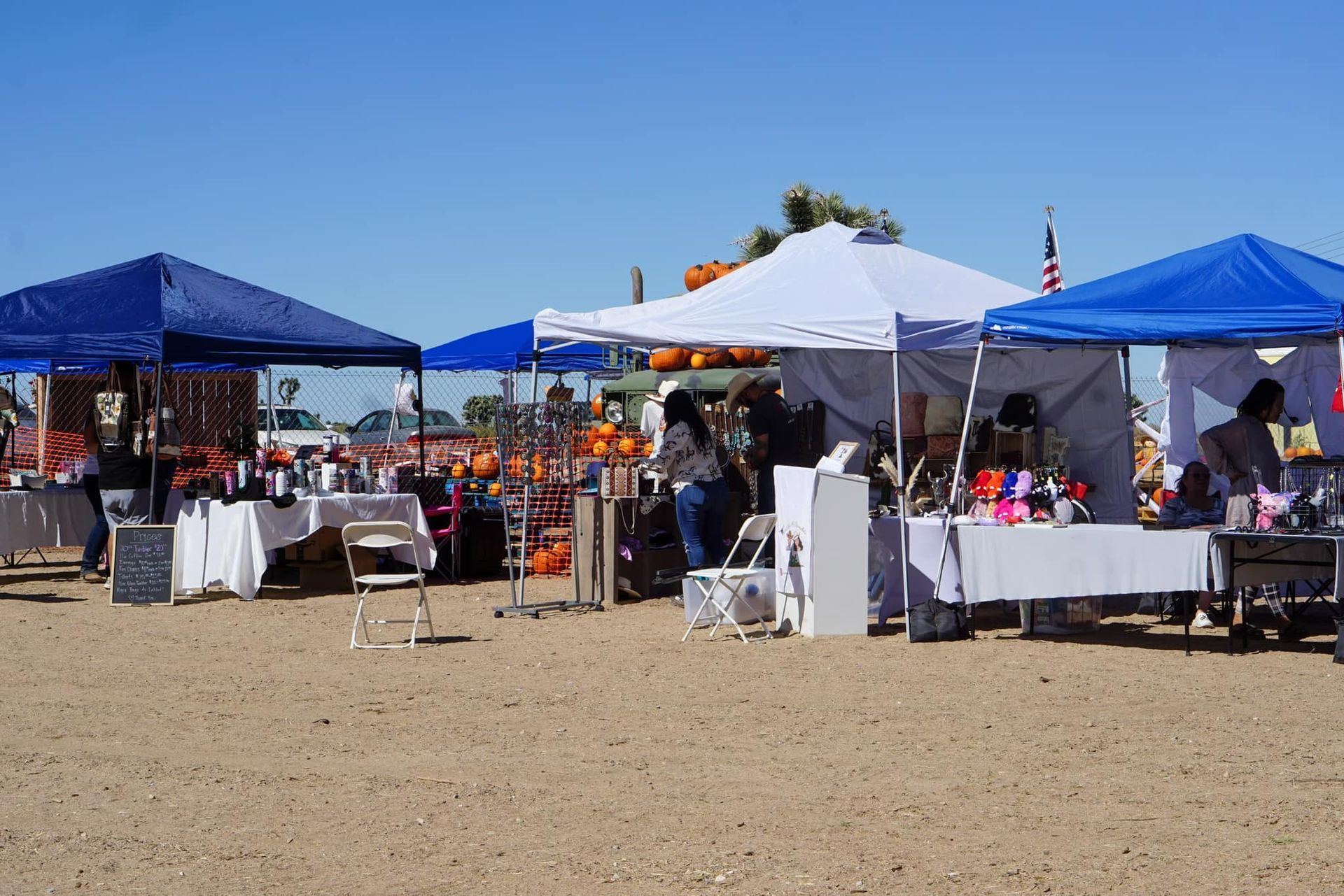 A group of tents are lined up on a dirt field.