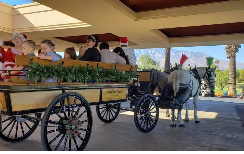 A group of people are riding in a horse drawn carriage.