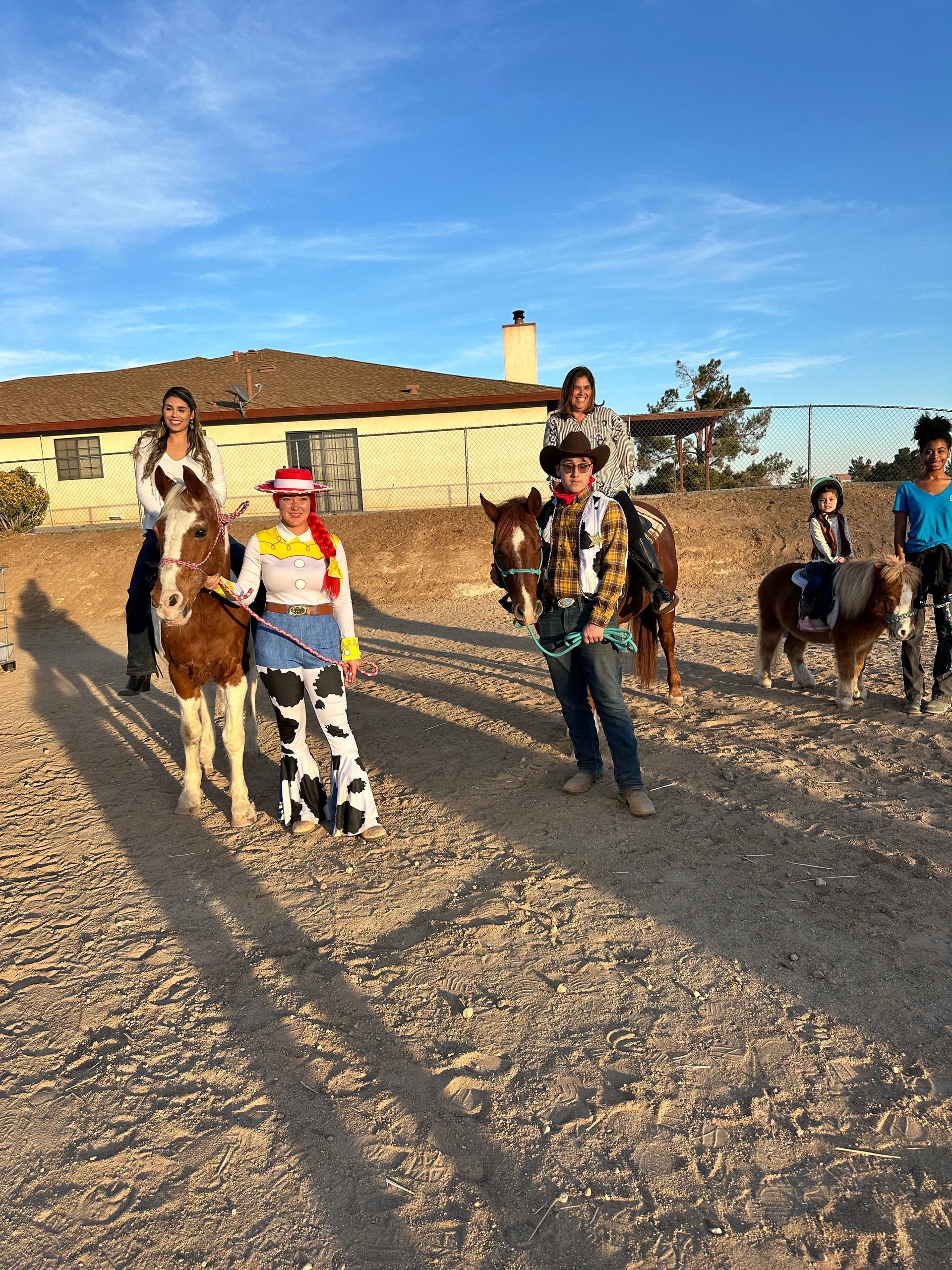 A group of people are riding horses on a dirt road.