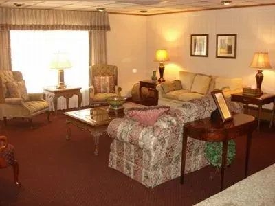 A living room with a couch , chairs , tables and lamps