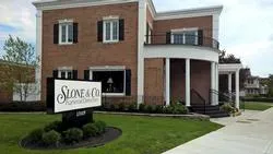 A large brick building with a sign in front of it.