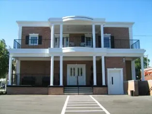 A large brick building with white columns and stairs