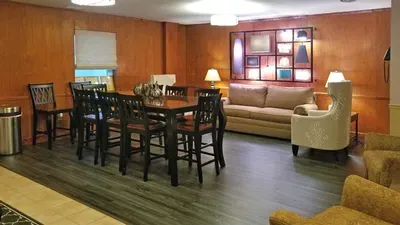 A living room with a couch , table , chairs and lamps.