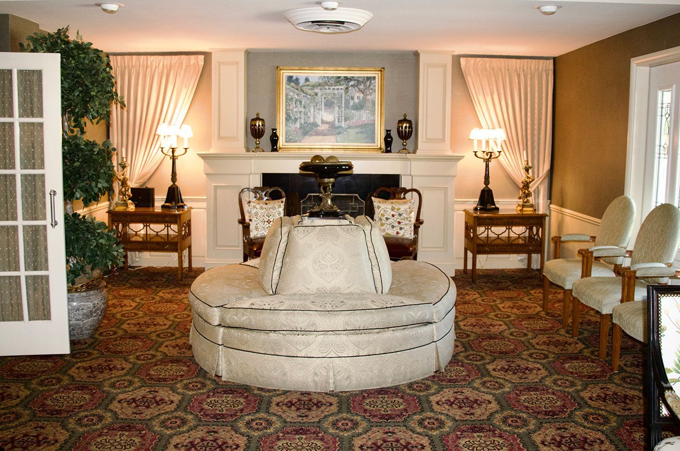 A living room with a round couch and a fireplace