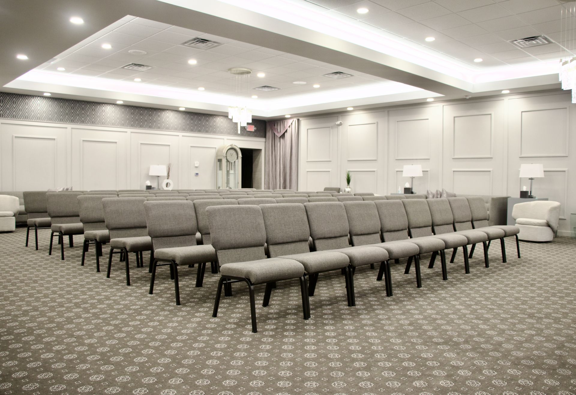 A large room with rows of chairs and a carpet.