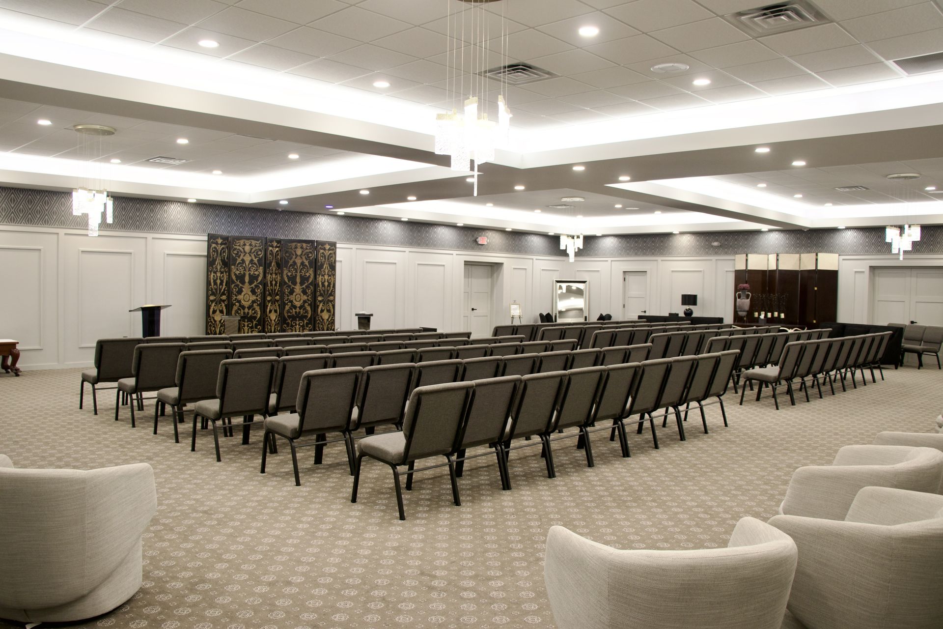 A large room with rows of chairs and a chandelier