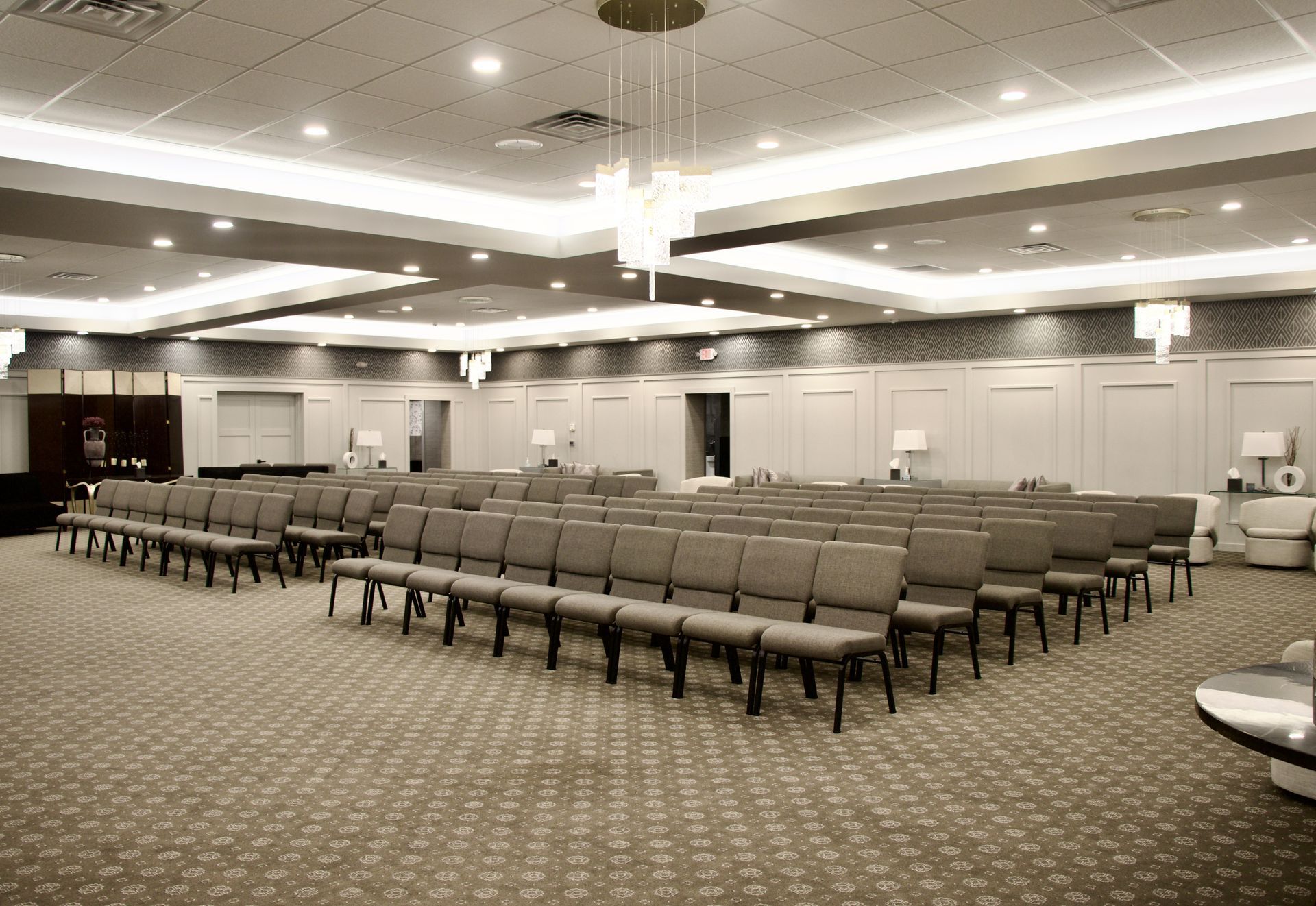A large room filled with rows of chairs and a chandelier.