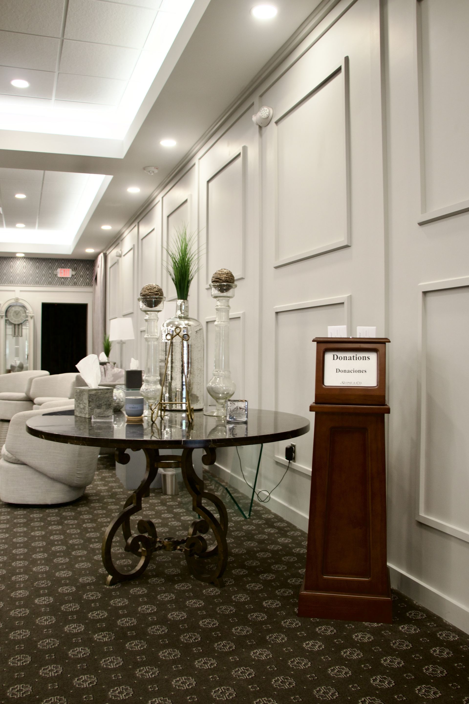 A room with a table and a clock in the middle of it.