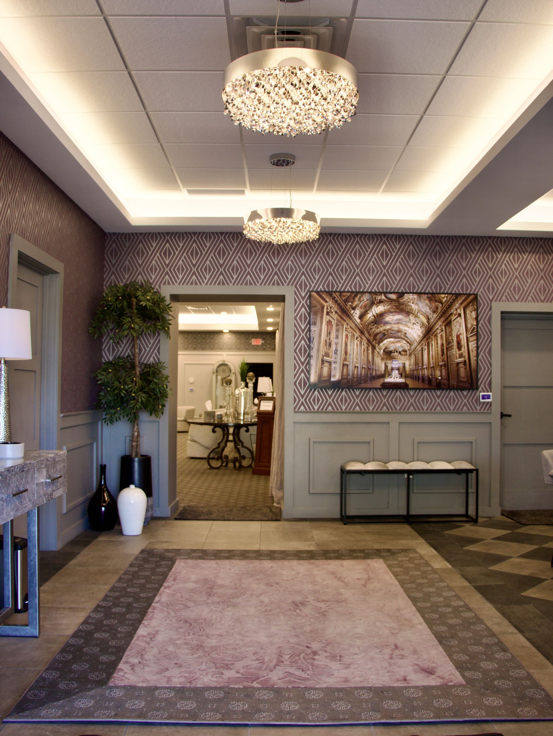 A hallway with a rug and a painting on the wall