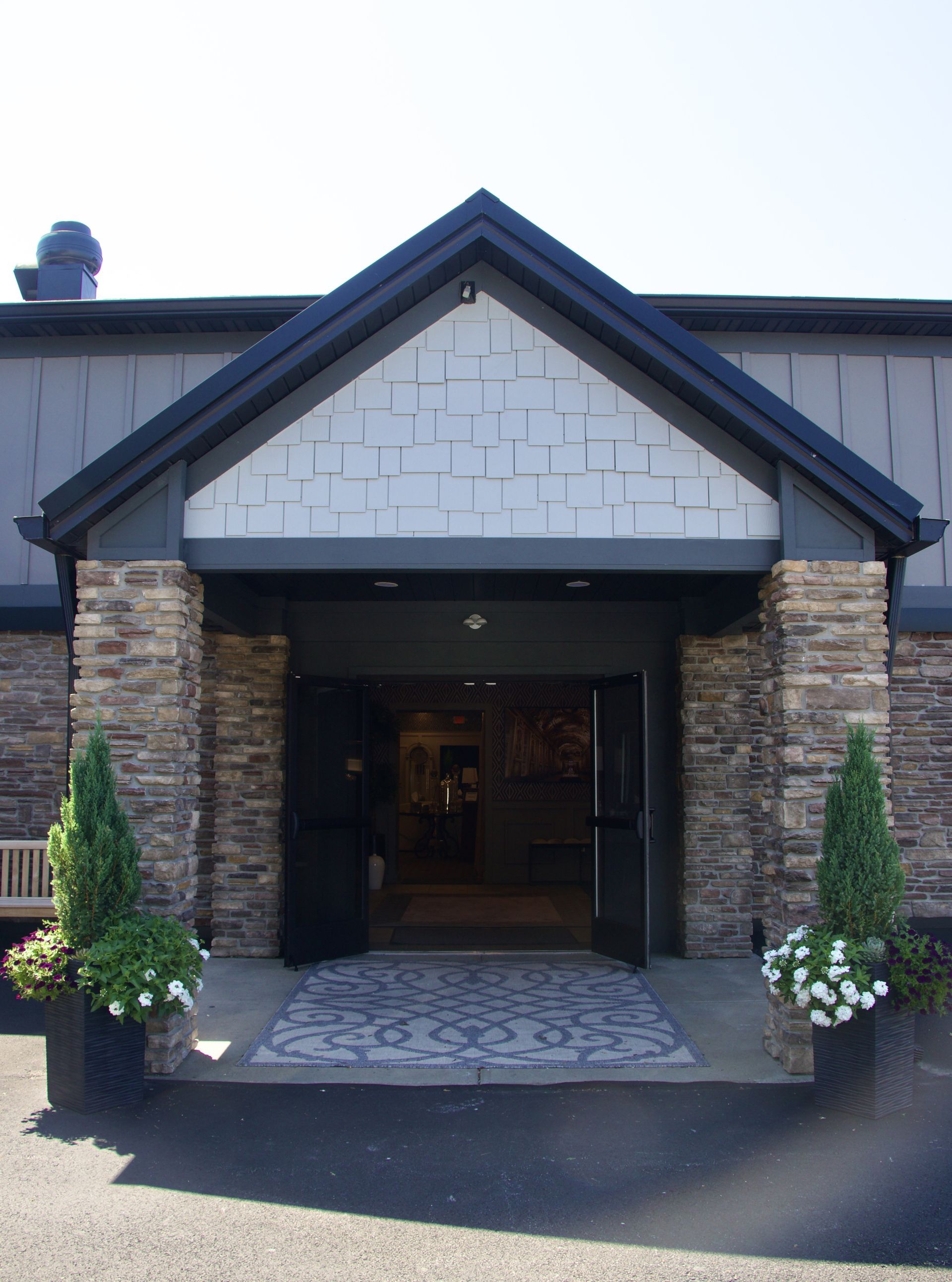 A stone building with a black roof and a black door