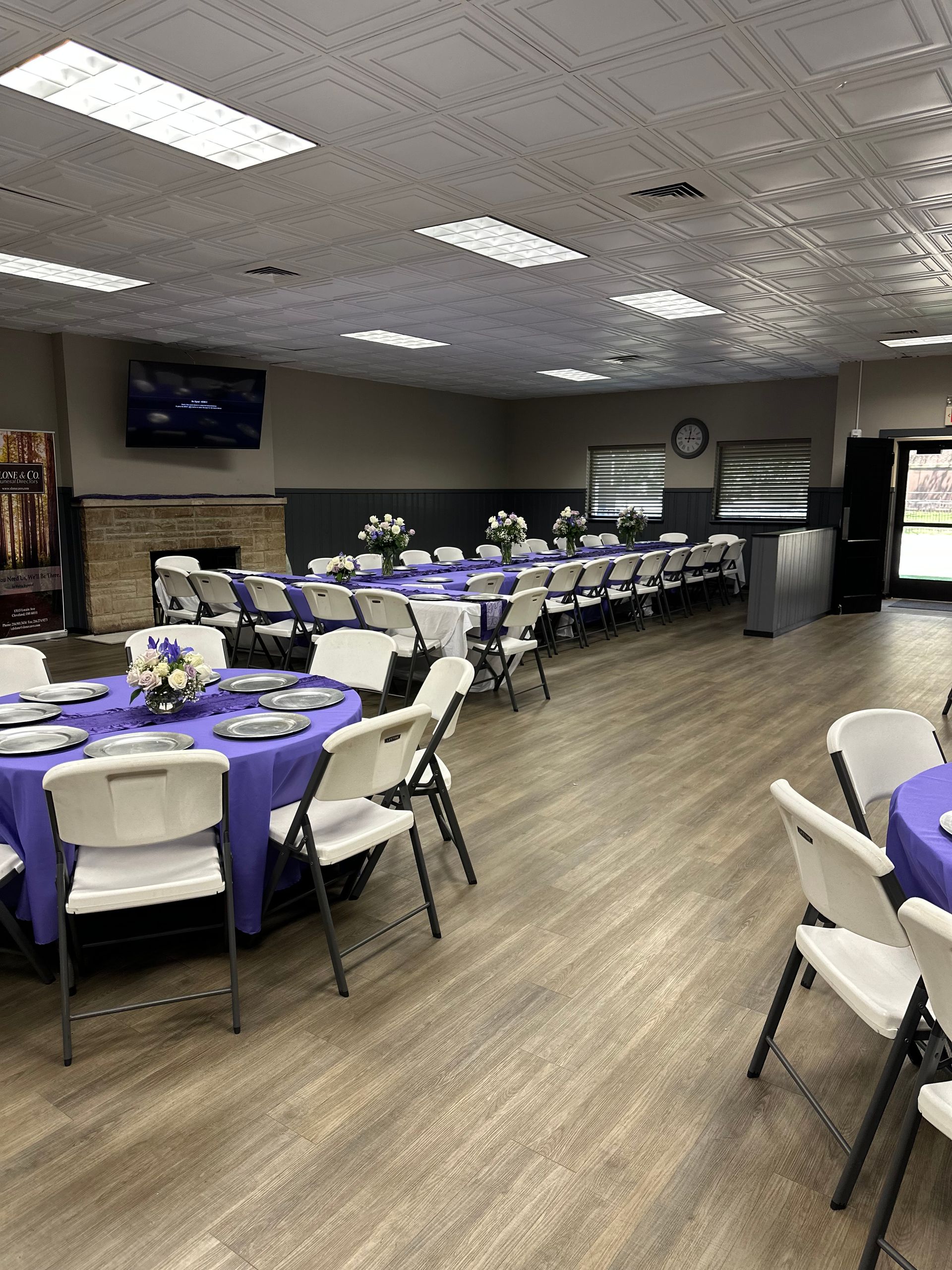 A large room with tables and chairs set up for a party.