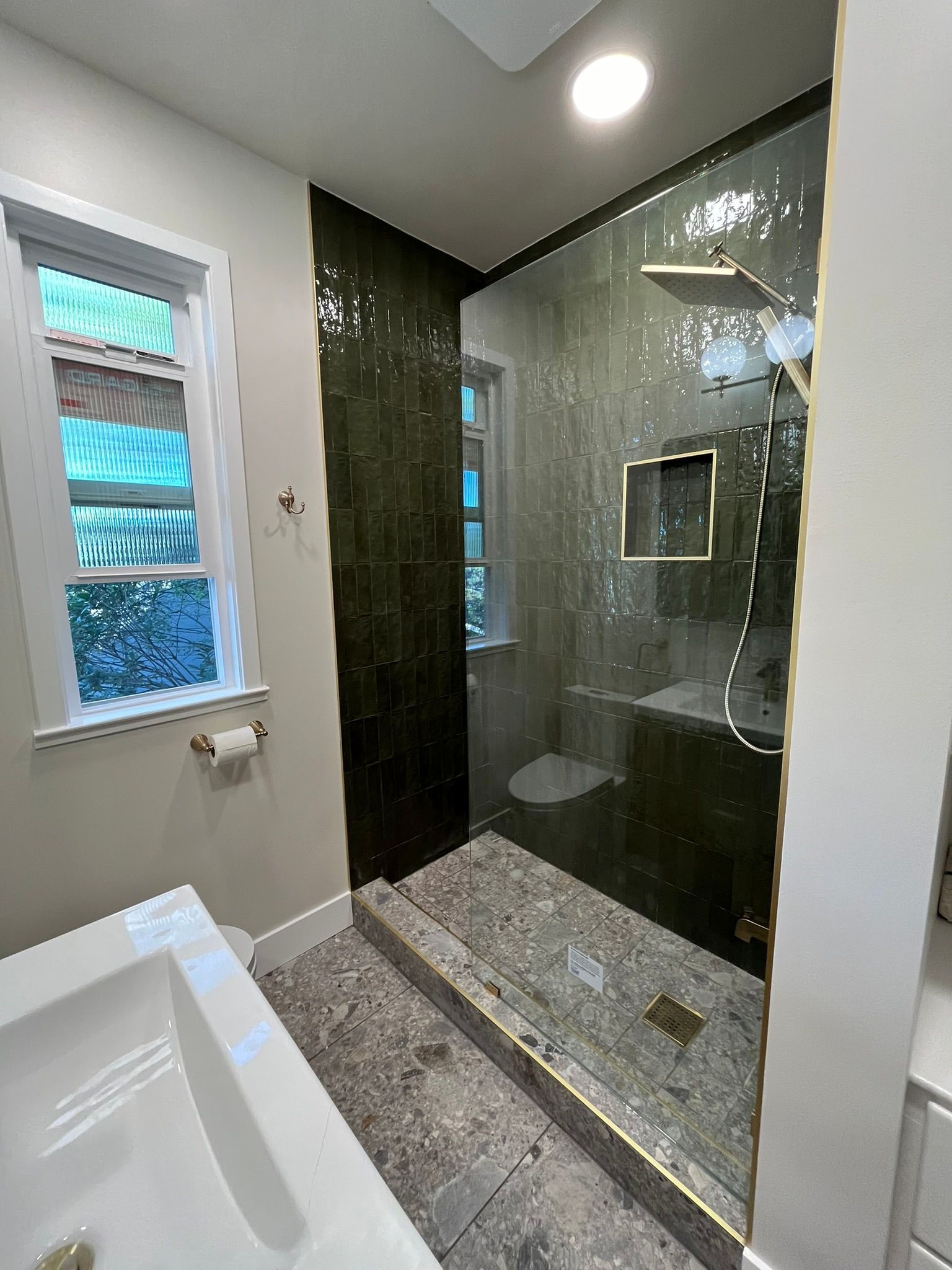 A bathroom with a tub , sink , toilet and shower.