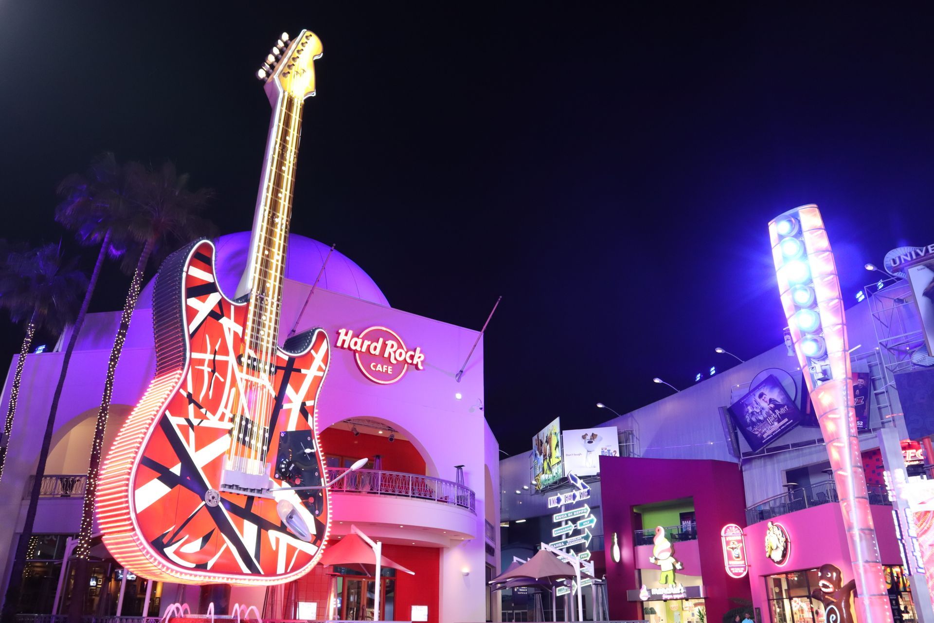 A large guitar is displayed in front of a hard rock cafe