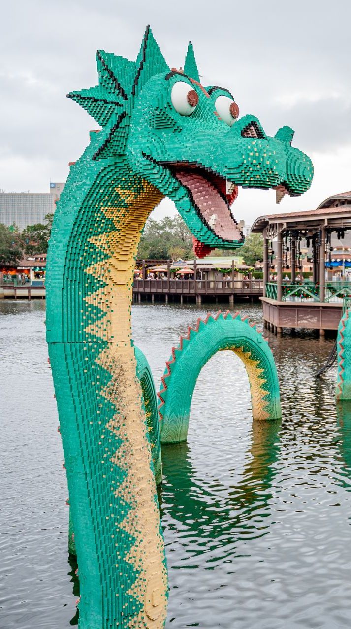 A green and yellow statue of a dragon is in the water