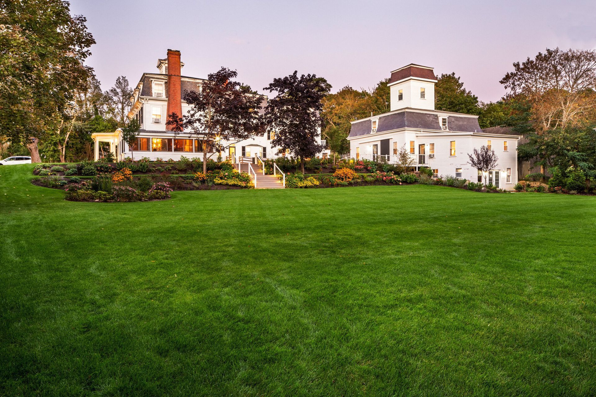 A large white house with a large lawn in front of it.