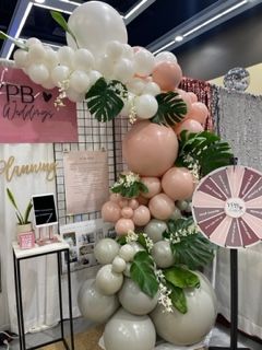 Organic balloon garland. whire pink grey neutral colors. weddings, upscale events. live fresh greenery botanicals Monstera added in balloon garland.