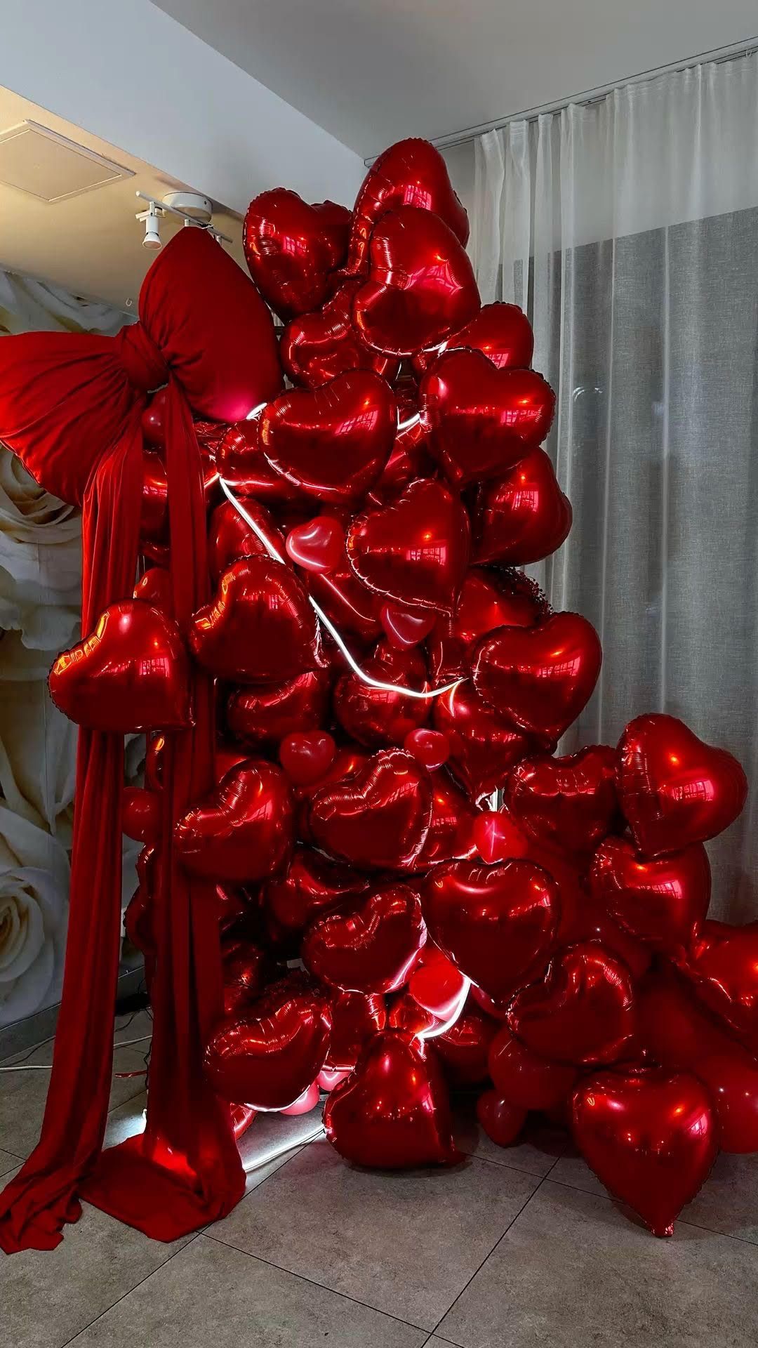 Red bow and mylar foil heart balloon with LED lights photo wall for Valentine's Day 