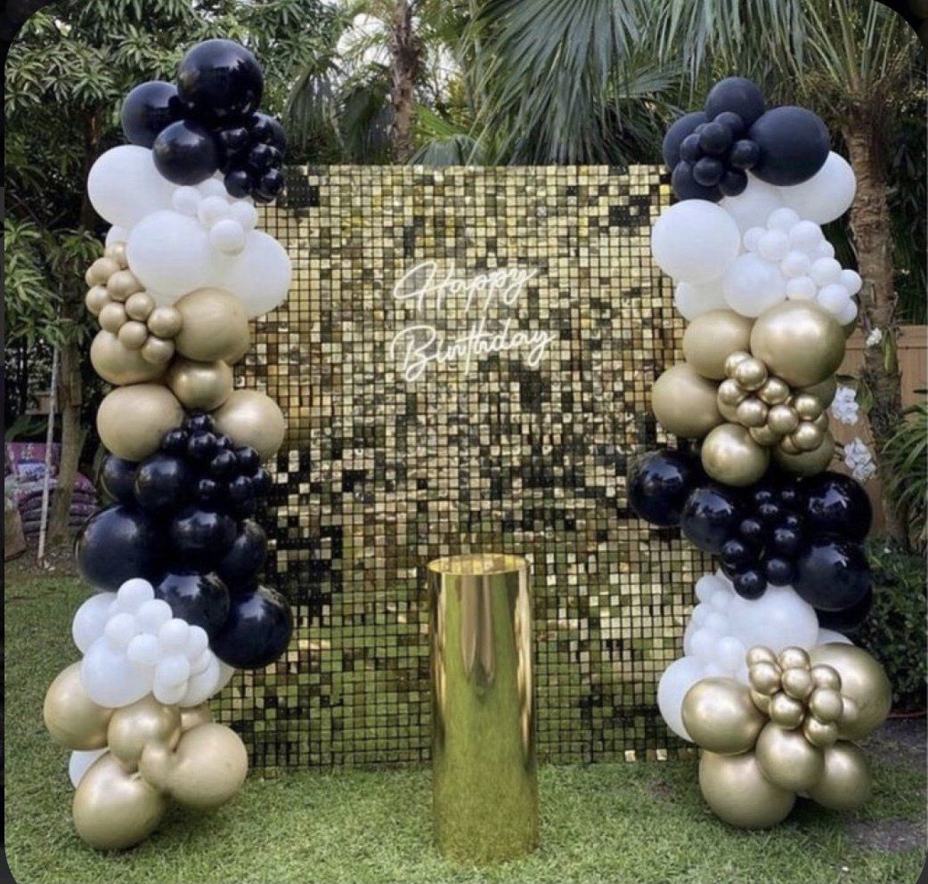 Black white and gold 'organic balloon garland' used for photo backdrop wall at large outdoor event.