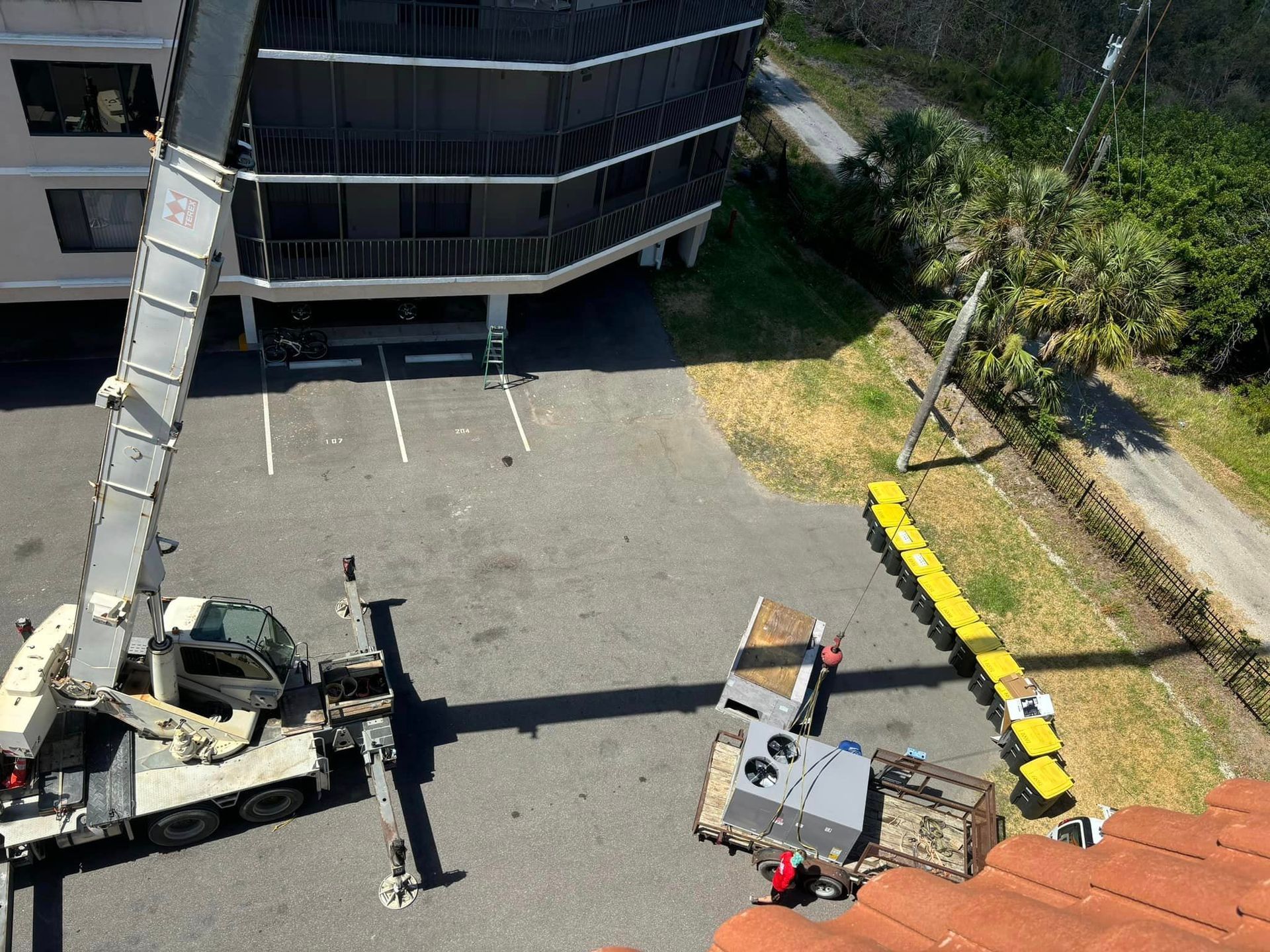 An aerial view of a crane in a parking lot