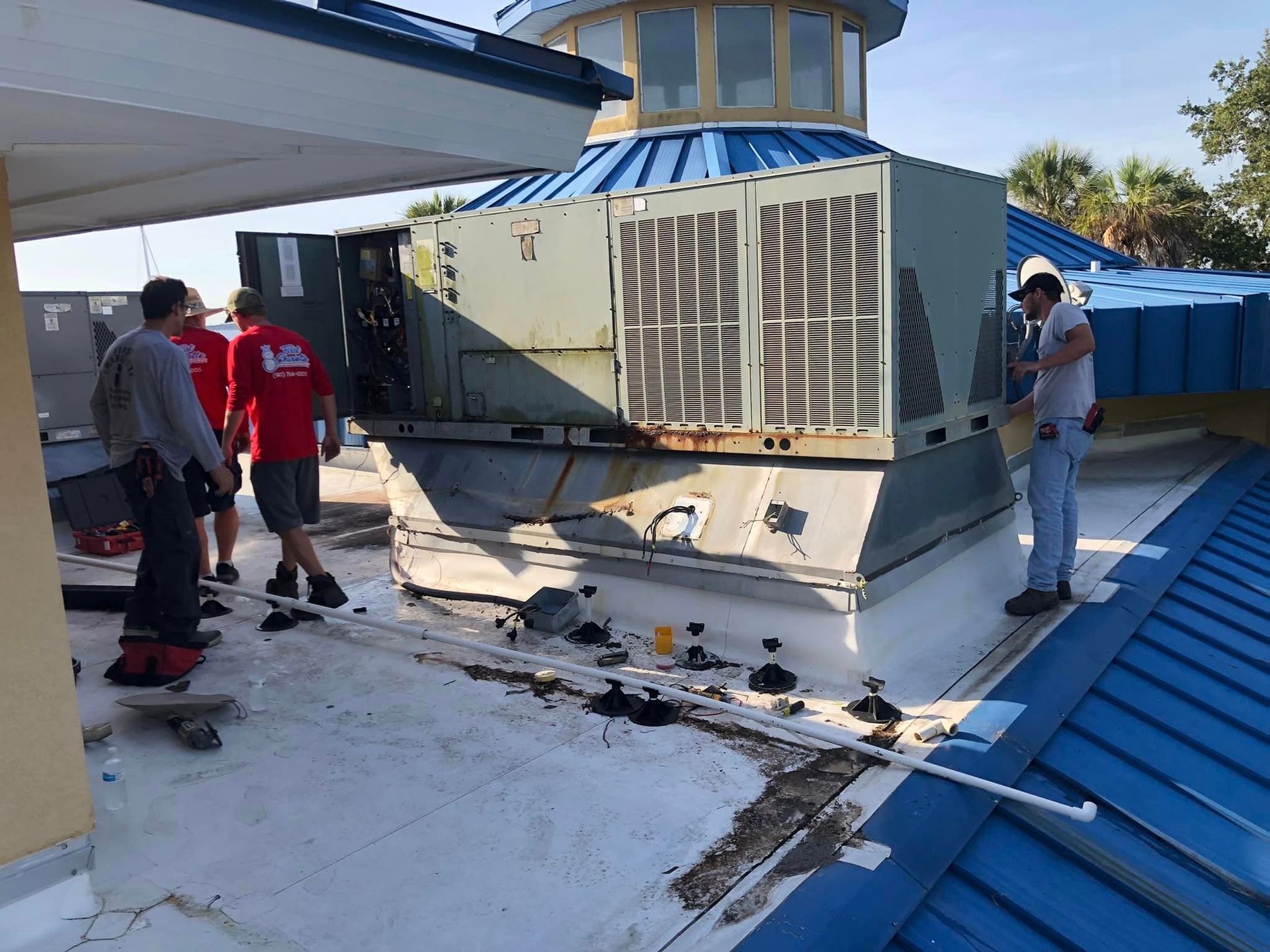 A group of men are working on the roof of a building.
