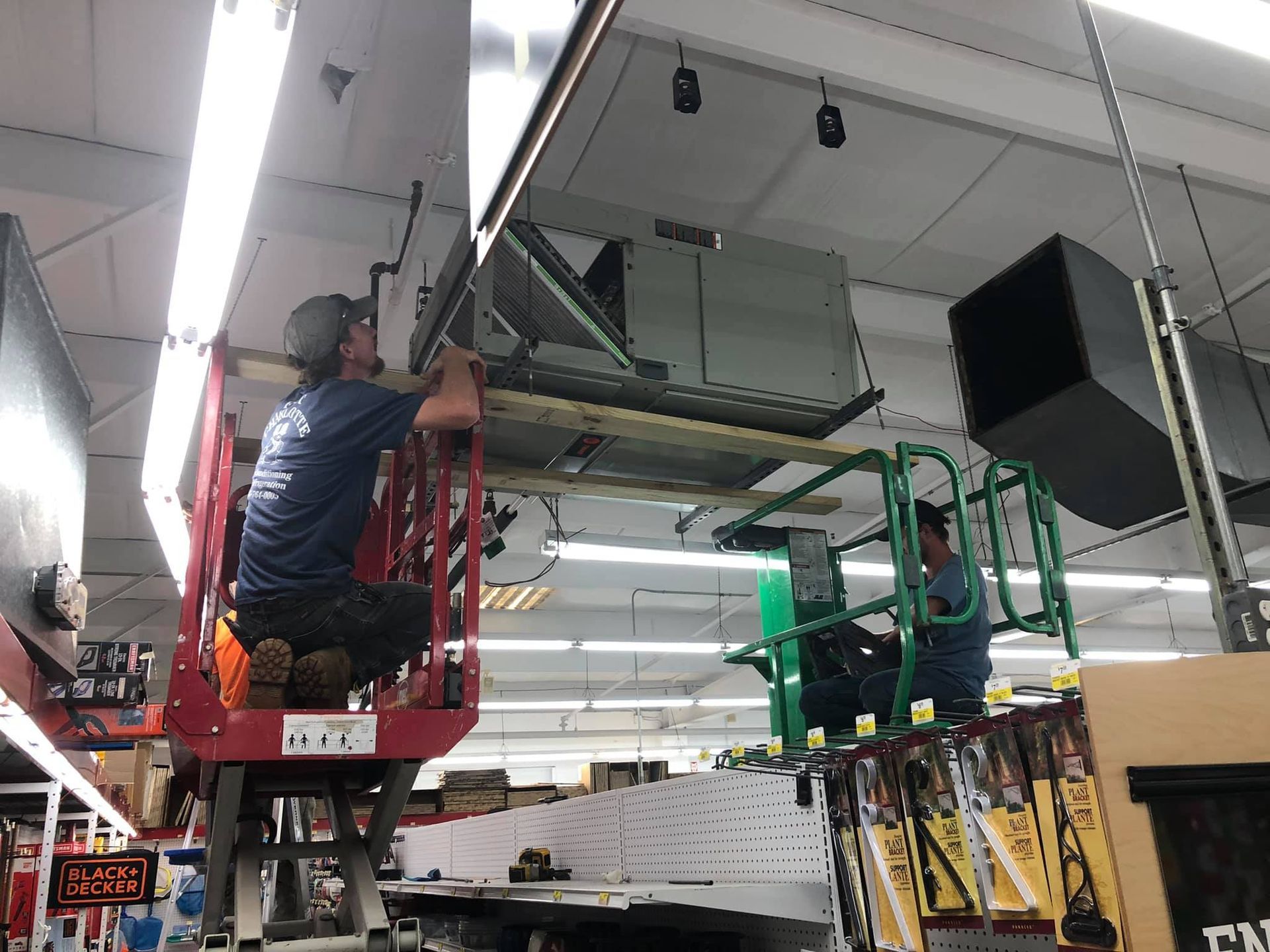 Two men are working on an air conditioner in a store.