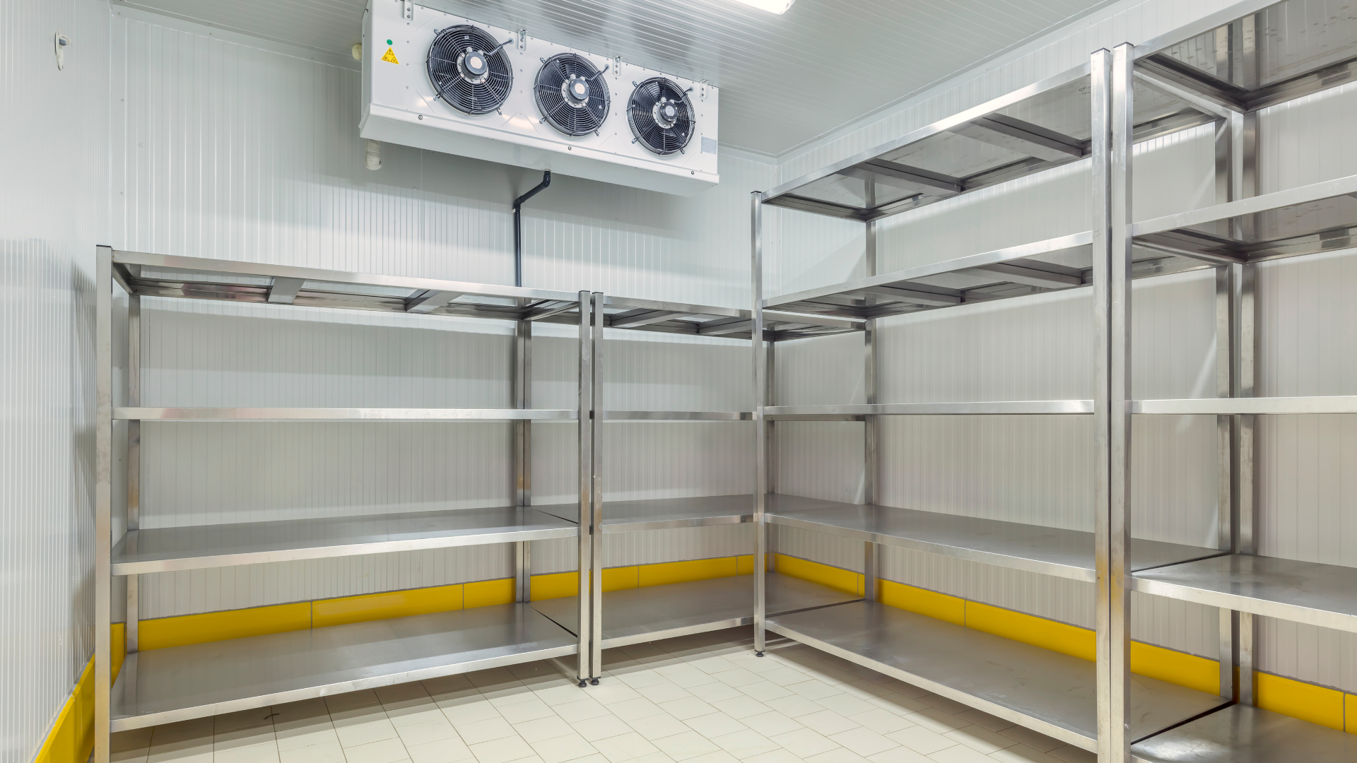 A room with stainless steel shelves and a refrigerator.