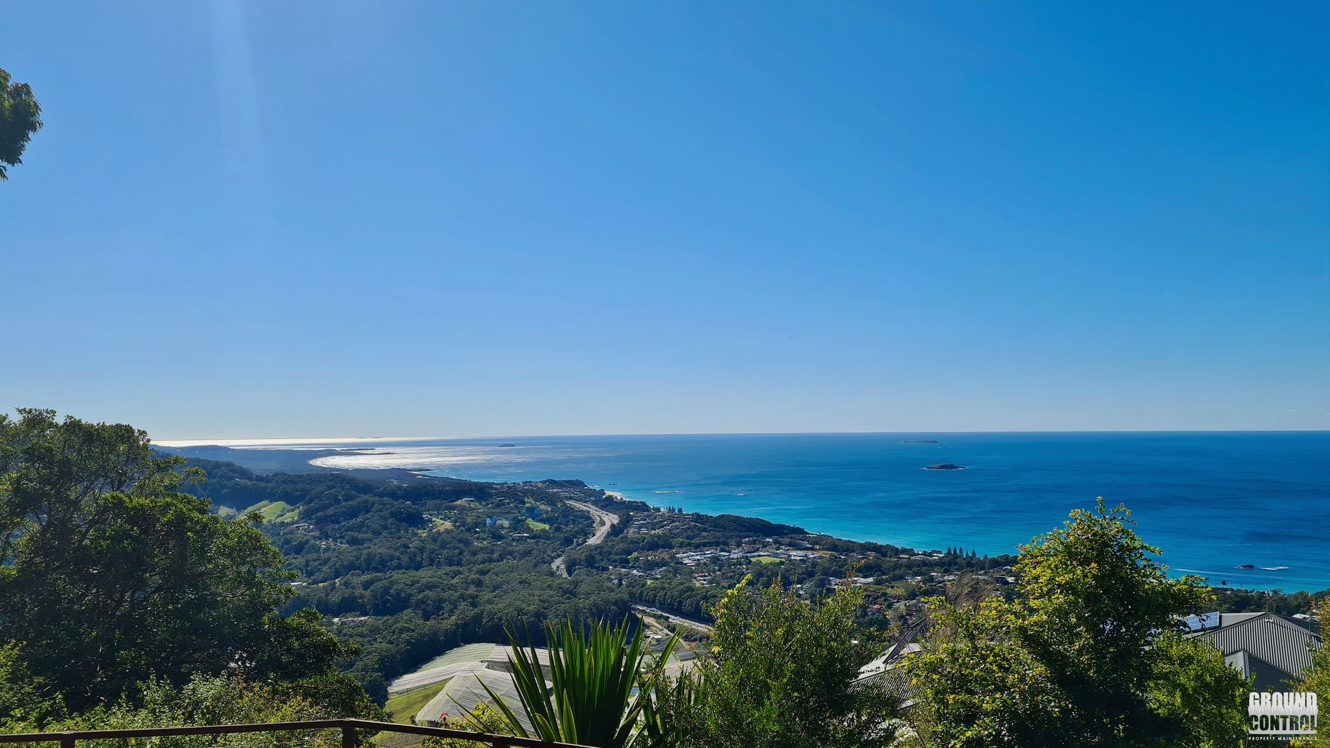 Coastal Bay with Blue Ocean, Sandy Shore, Green Hills, and Clear Sky on A Sunny Day — Ground Control Property Maintenance in North Boambee Valley, NSW