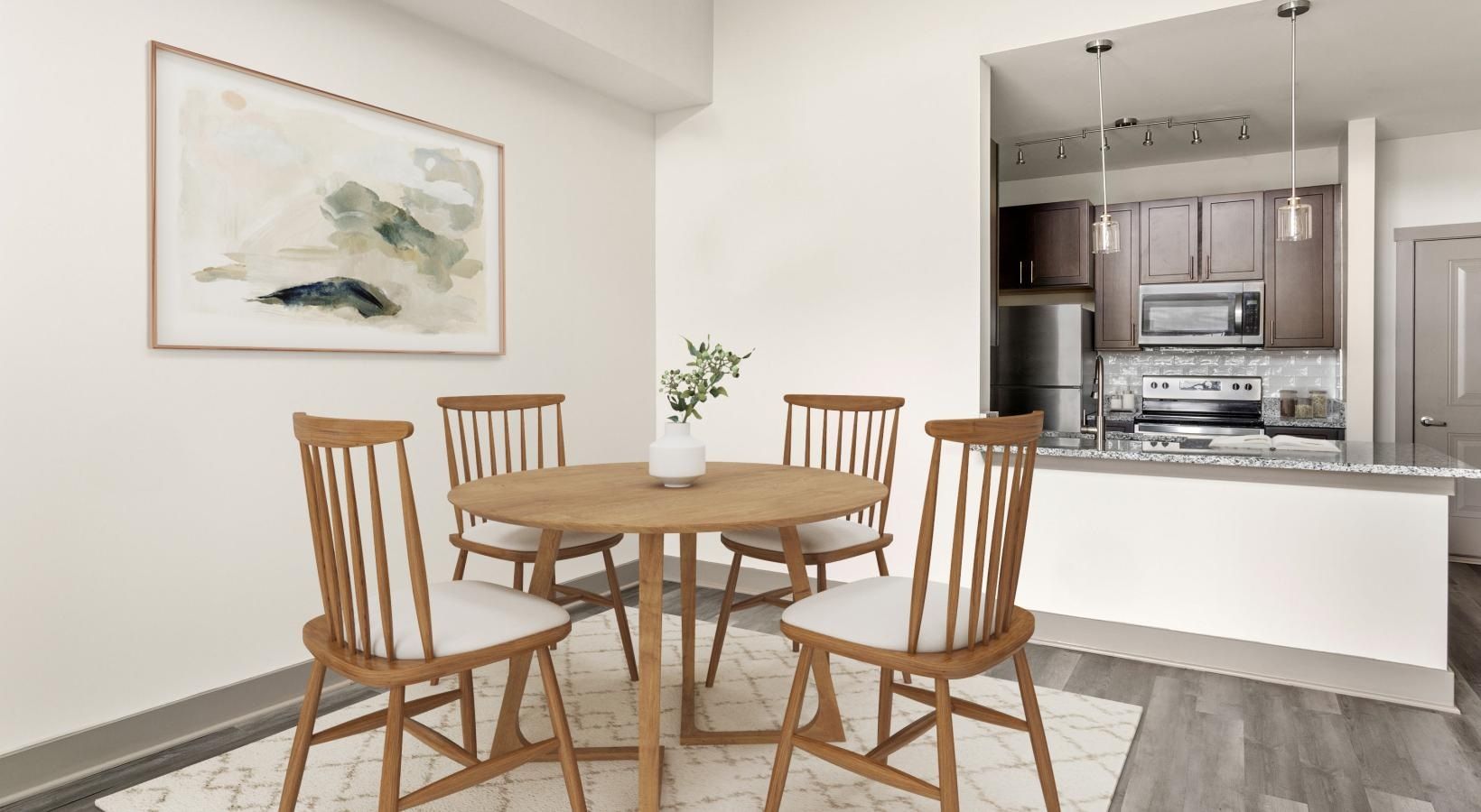 A dining room with a table and chairs and a painting on the wall.