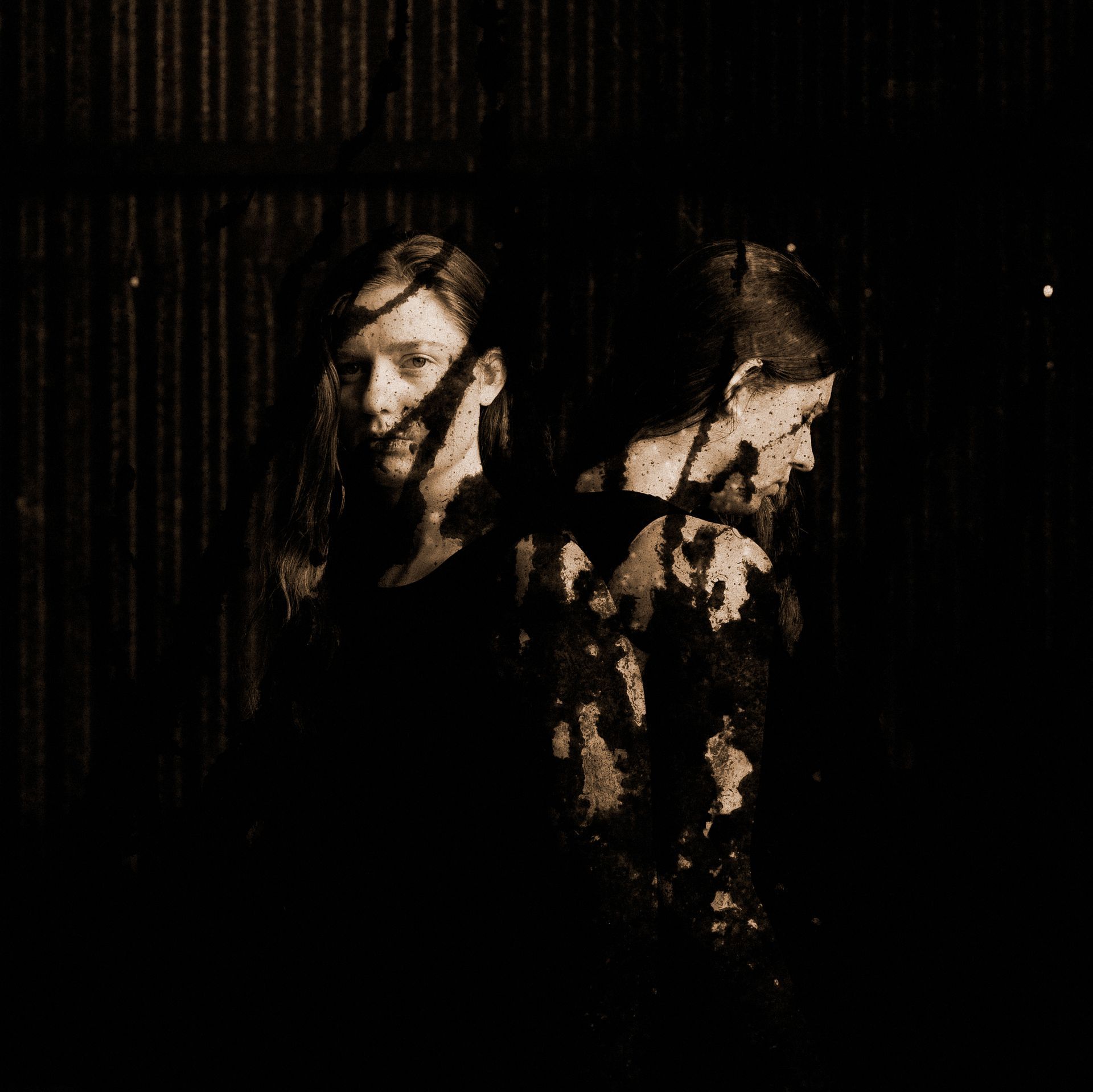 Two women are standing next to each other in a dark room.