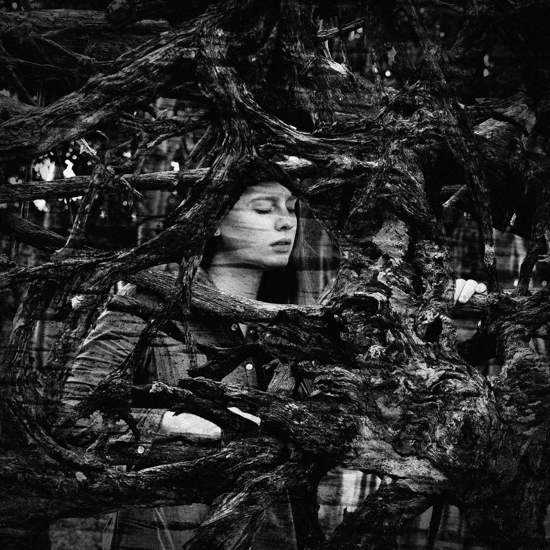 A black and white photo of a woman surrounded by trees