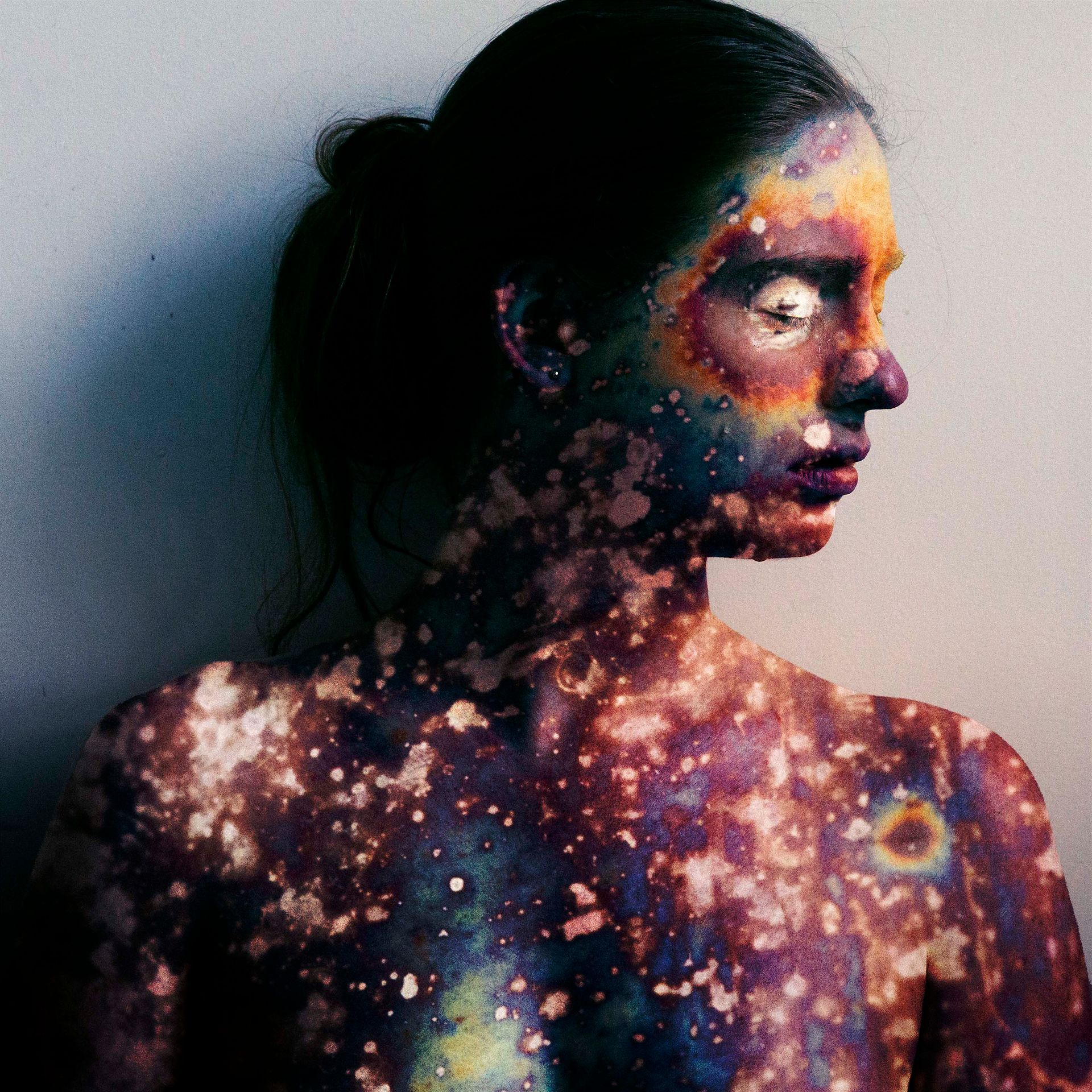 A woman with colorful paint on her face and body