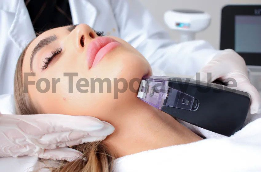 Woman receiving neck treatment with a handheld device in a medical setting.