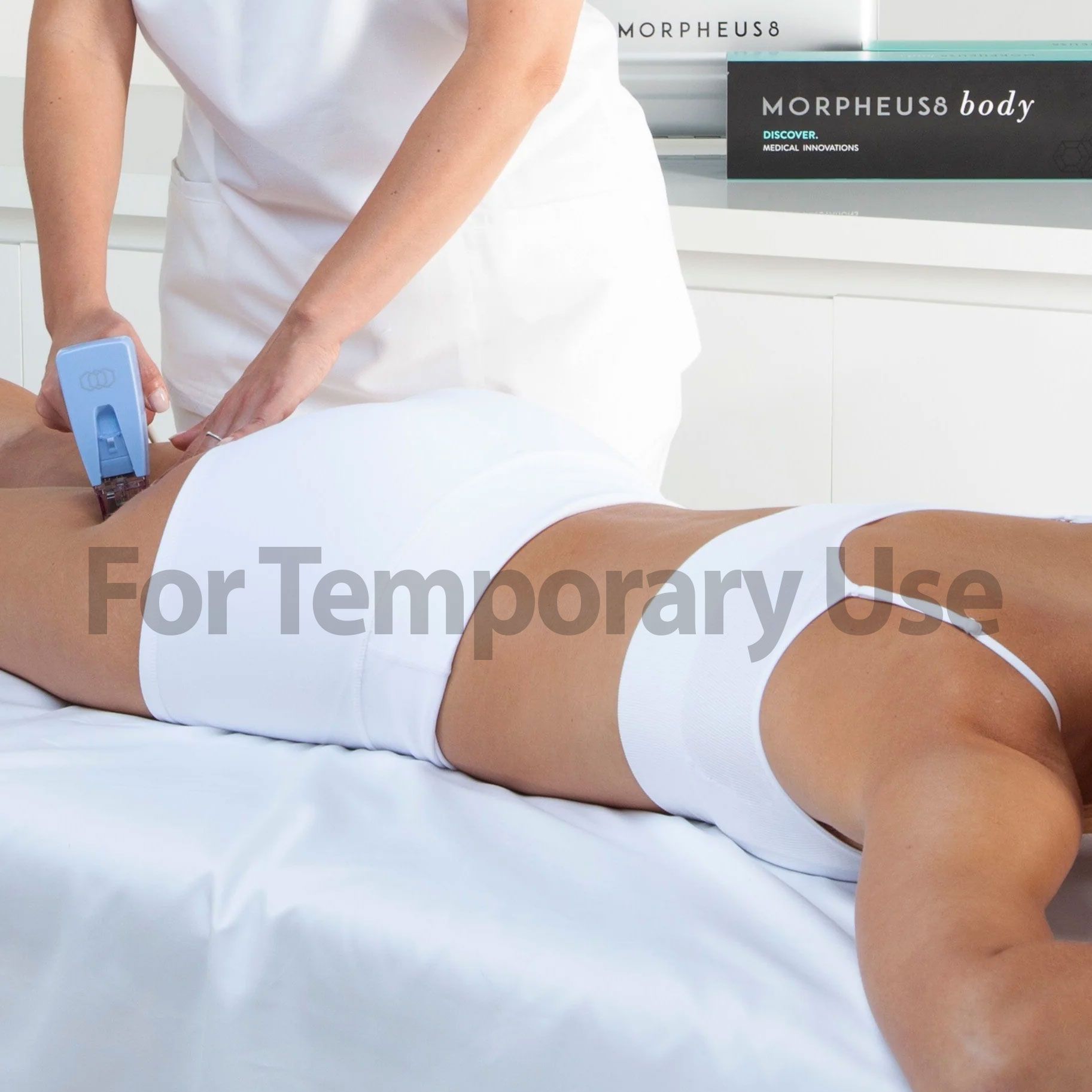 Person receiving body treatment in a clinic; a medical device is applied to the body.