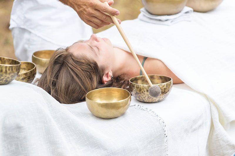 Woman receiving body contouring treatment with a handheld device on her thigh.