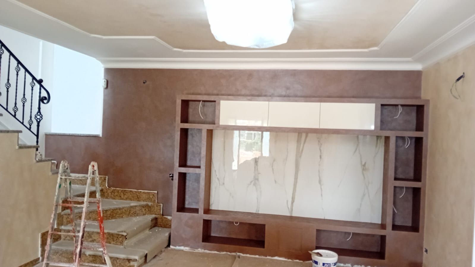 Un soggiorno con un grande centro di intrattenimento e scale.