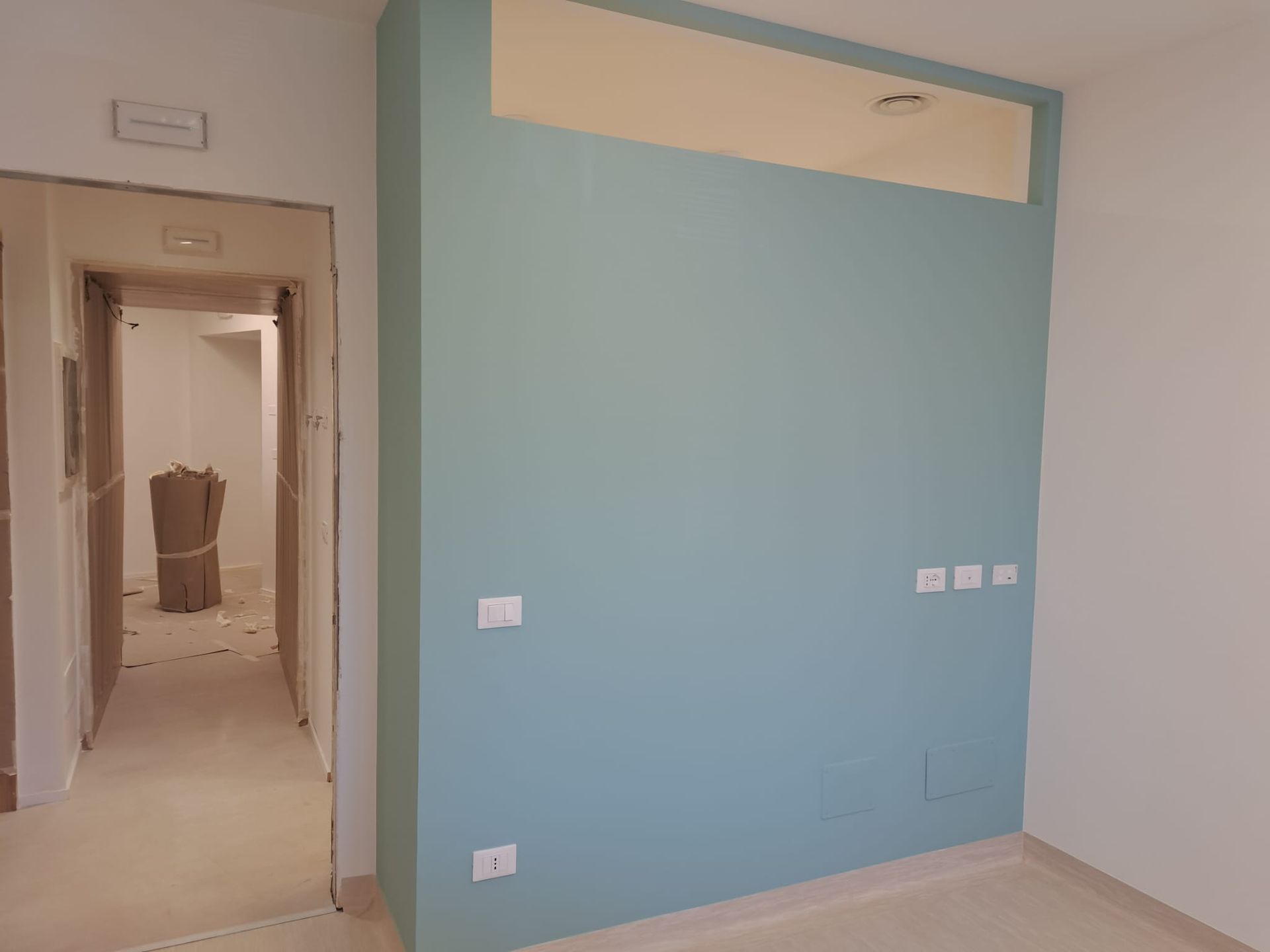 Una stanza con un muro blu e una porta bianca.