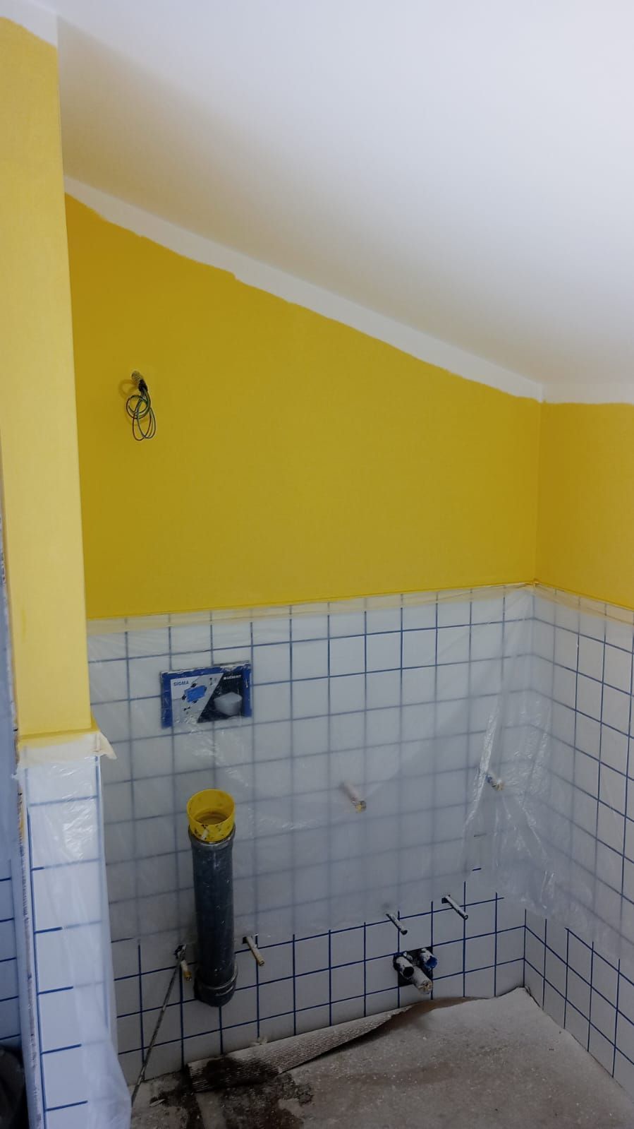 Un bagno con pareti gialle e piastrelle bianche